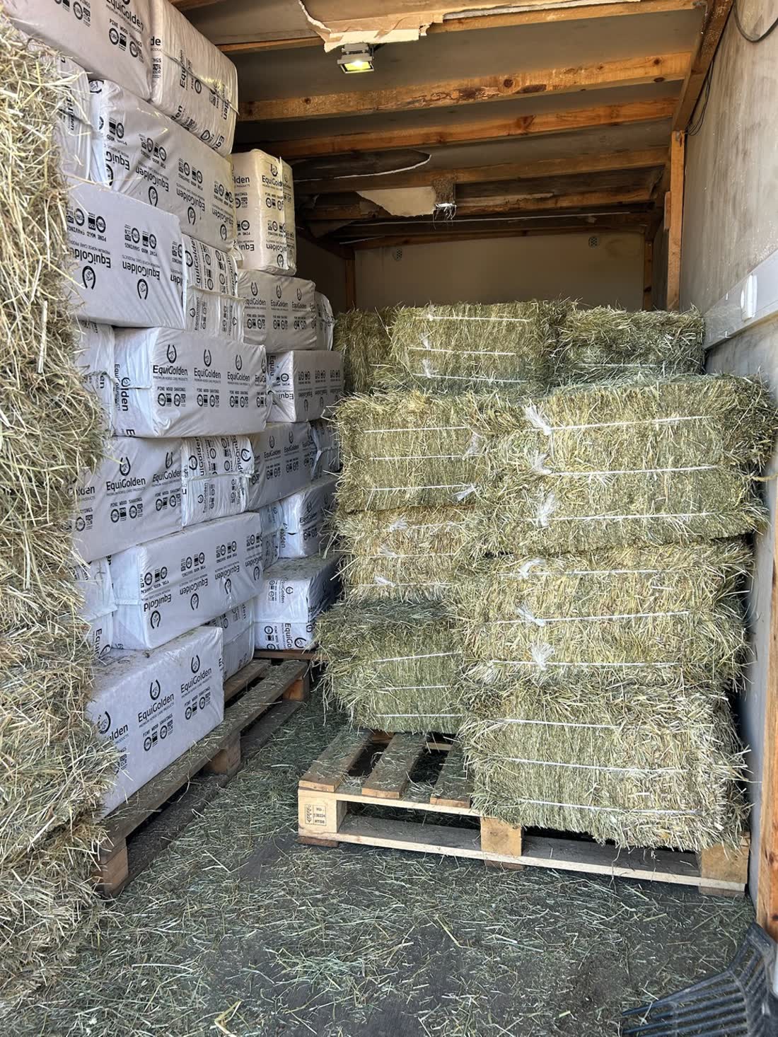 Pallets of hay and bags of shavings ready for one delivery